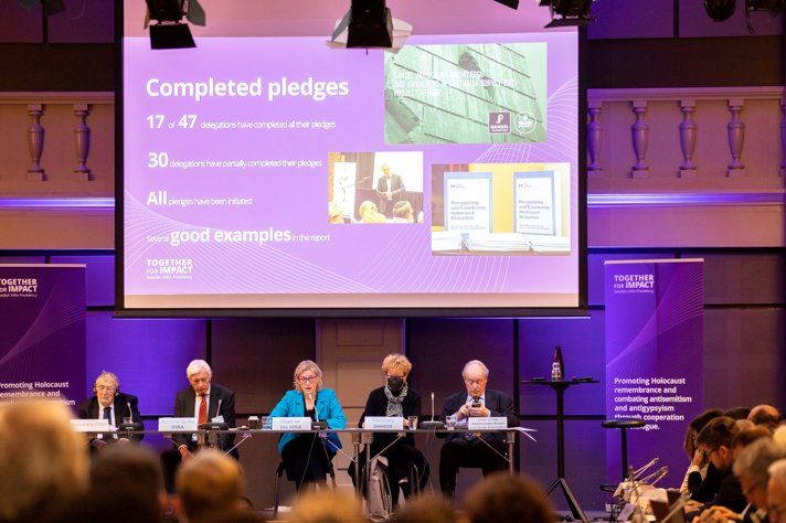 Five members of the panel on stage in front of the audience.