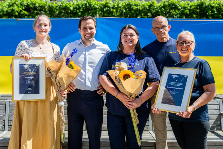 Benjamin Dousa togheter with Elly Reinolds and representatives from OperationChange. The recipients are holding flowers and diplomas.