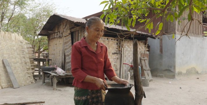 Woman filling up container with water.
